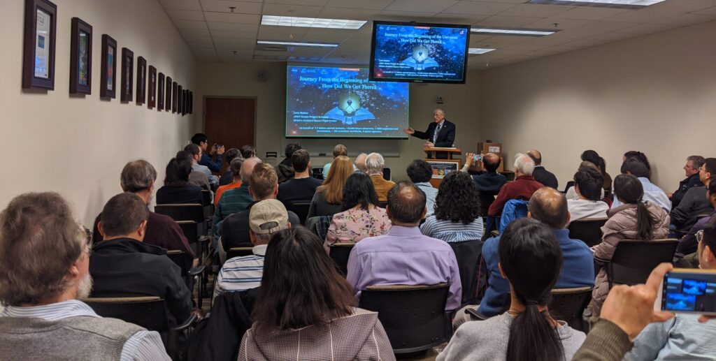 A seminar speaker presents to a large group of attendees