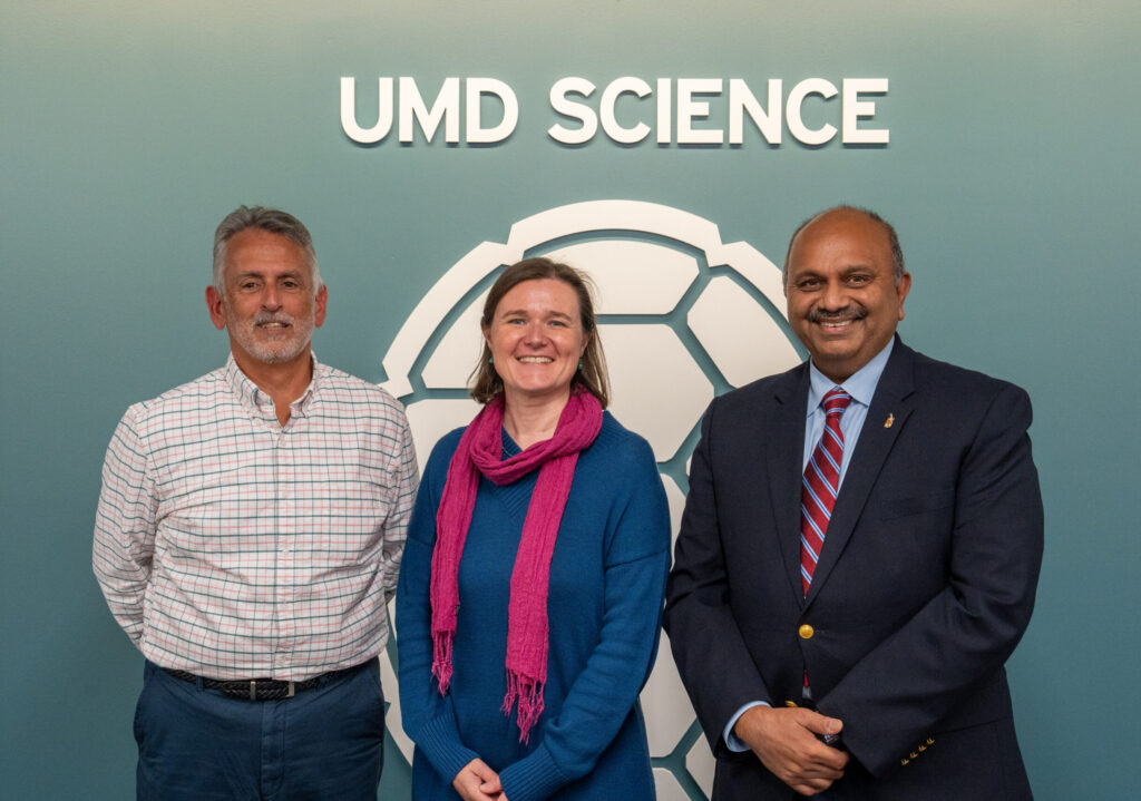 Ralph Ferraro, Lisa Milani, and Amitabh Varshney pose in front of the UMD Science backdrop at the event.