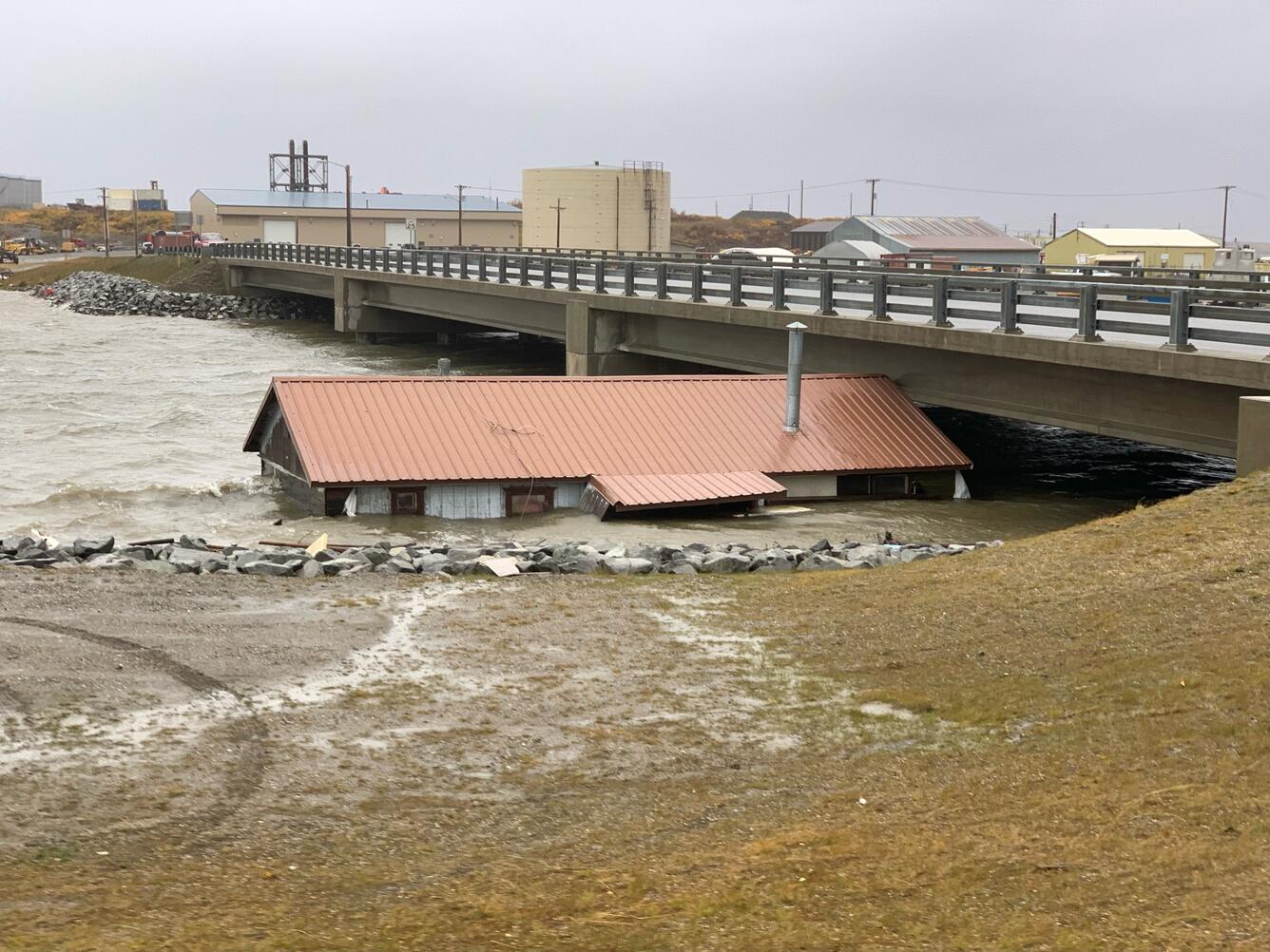 A building lifted from its foundation by floodwater from Extratropical Typhoon Merbok, trapped under a bridge in Nome, Alaska. Source: Coastal and Marine Hazards and Resources Program