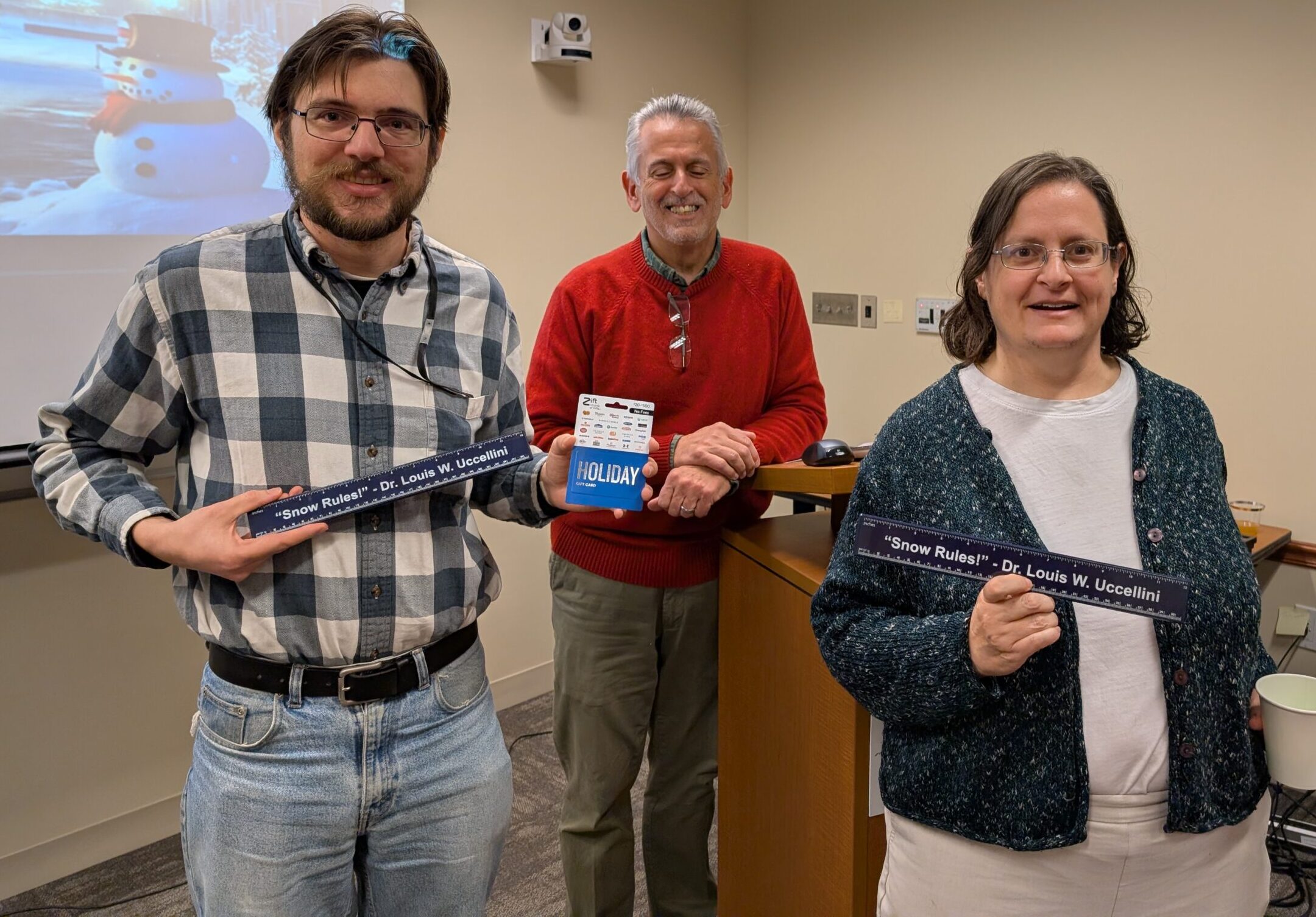 Chip Helms and Corinne Carter pose with Ralph Ferraro, and show off their Louis Uccellini snow rulers