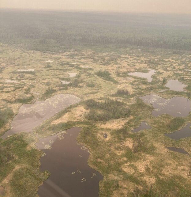 Permafrost thaw bogs in the Northwest Territories, Canada. A nearby fire caused haze in the scene. Photos were taken from a helicopter.