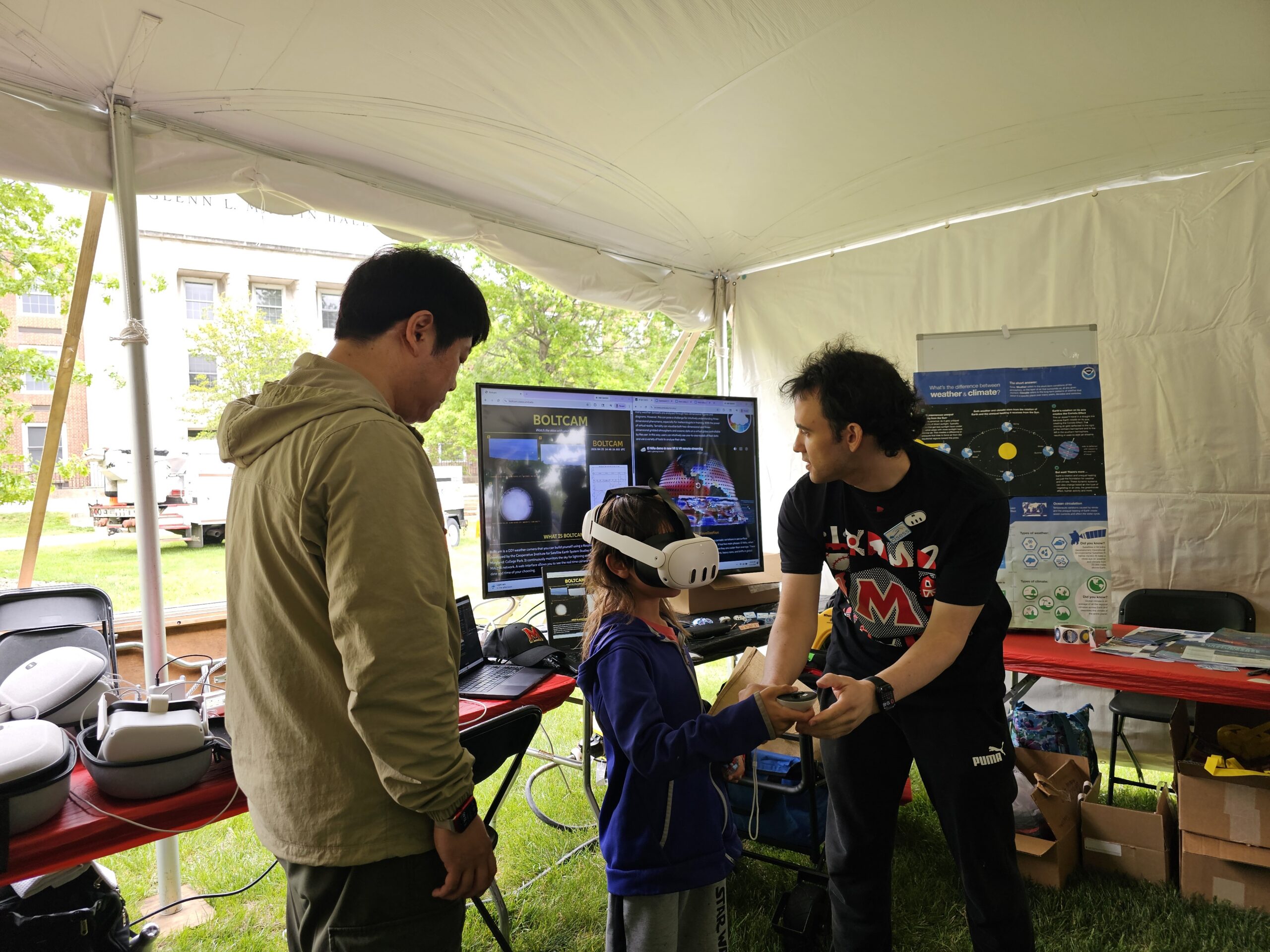 Two scientists assist a child with a VR game.